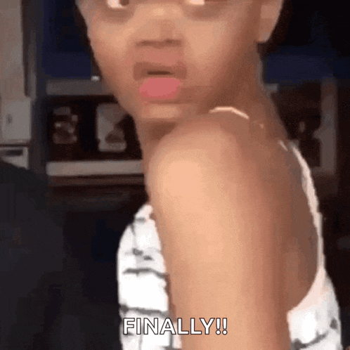 a little girl is making a funny face with her tongue out and says `` finally '' .