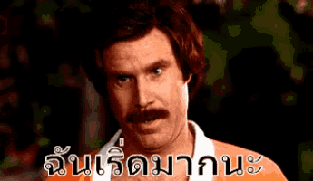a man with a mustache is wearing an orange shirt and has a foreign language written on his shirt
