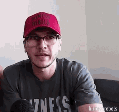 a man wearing a red hat that says bizness rebels on it