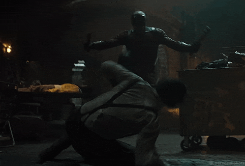 a man kicking another man in a dark room with daredevilshots written on the bottom right