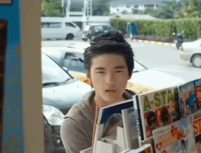 a young man holds a magazine that says a-star