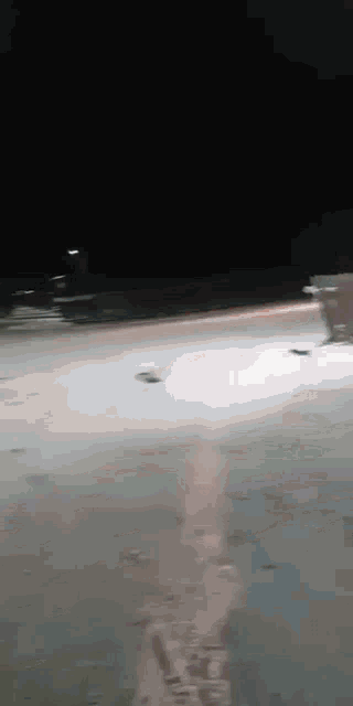 a car is driving down a road at night with the lights on