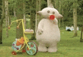 a stuffed animal is standing next to a bicycle in a field .
