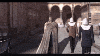 a man in a cape is walking with two nuns