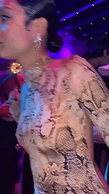 a woman in a snake print dress is dancing