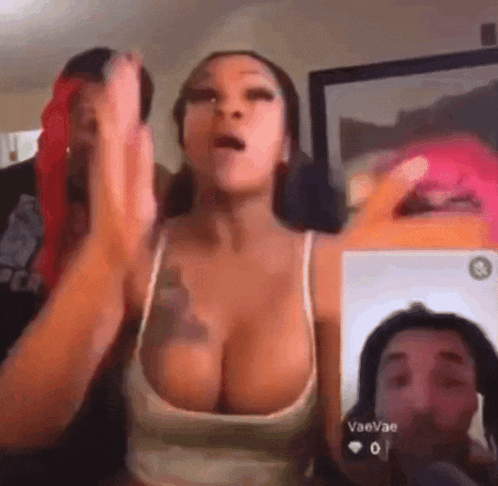 a woman with large breasts is talking to a man