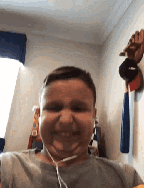 a young boy wearing headphones is smiling in a room