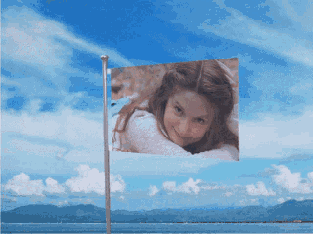 a flag with a picture of a girl on it is flying in the wind