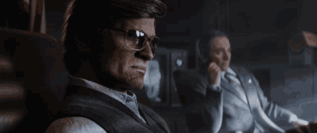 a man wearing sunglasses is sitting next to another man