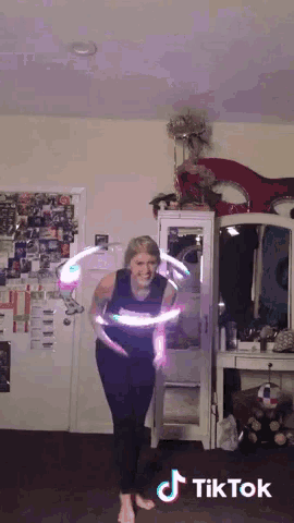 a tiktok video of a woman spinning a hula hoop in a room