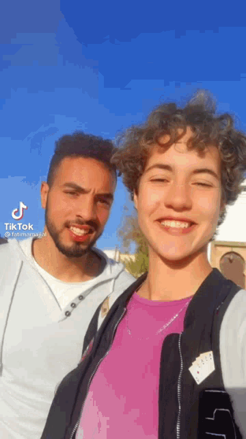 a man with a beard and a woman with curly hair are posing for a picture with tik tok written in the corner