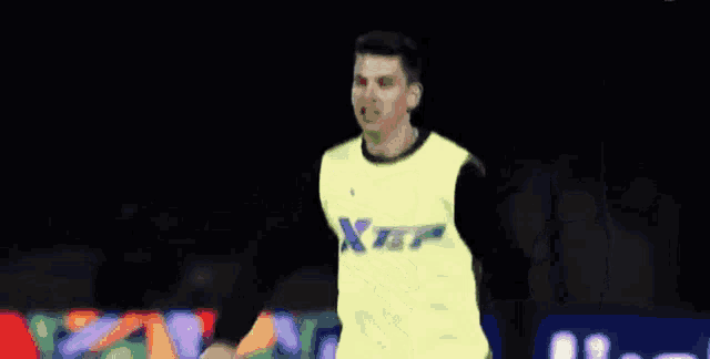 a man wearing a yellow vest that says xter on it