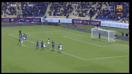 a soccer game is being played in a stadium with qatar advertisements on the sidelines