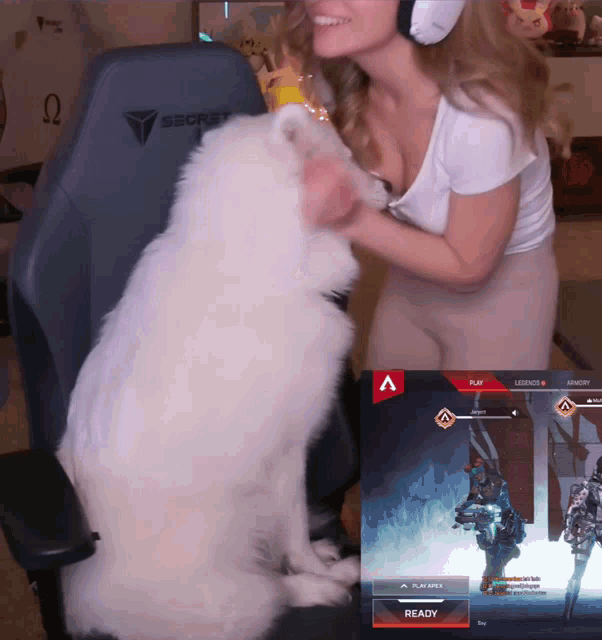 a woman is petting a white dog in front of a secret gaming chair