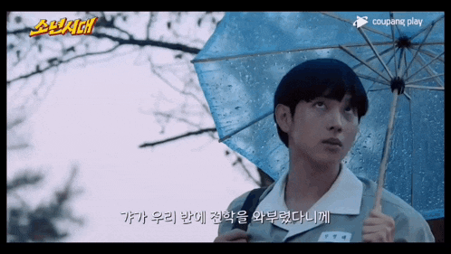 a boy holding an umbrella in the rain with a coupang play logo