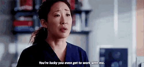 a woman in scrubs is talking to a man in a hospital room .