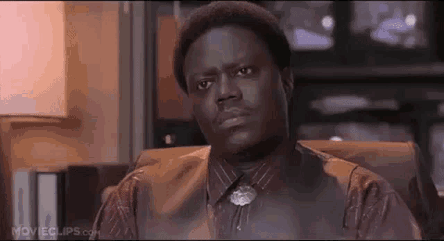 a man in a suit and tie is sitting in a chair .
