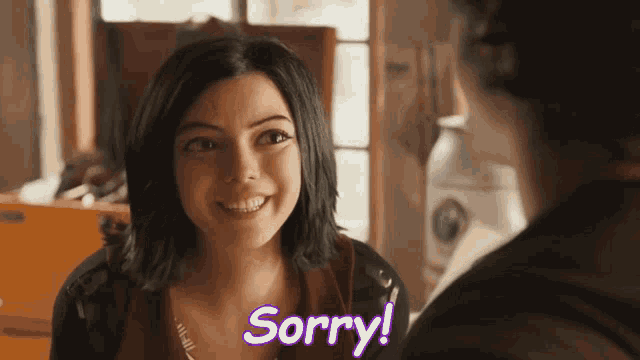 a woman says sorry while smiling and looking at another person