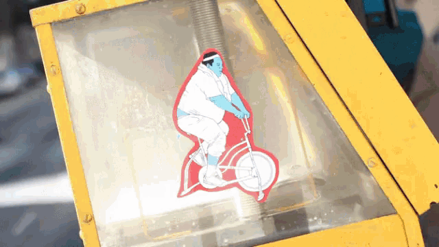 a sticker of a man riding a bike is on a yellow box