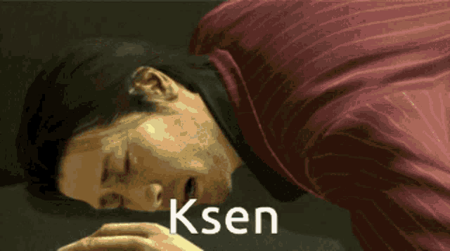 a man in a red striped shirt is laying down with the word ksen written below him