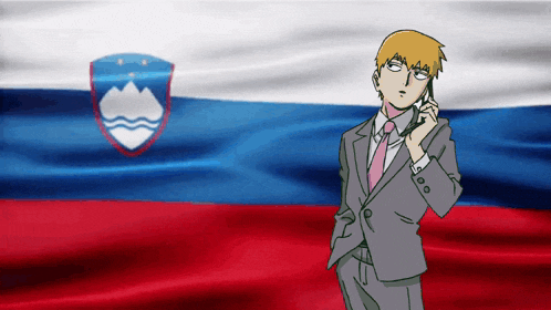 a man in a suit talks on a cell phone in front of a russian flag