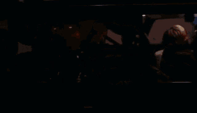 a woman is driving a car at night in a parking garage .