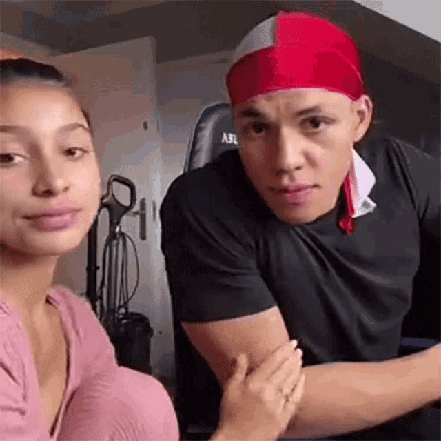 a man and a woman are sitting next to each other . the man is wearing a red headband .