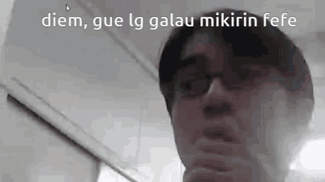 a man wearing glasses is making a funny face while standing in front of a mirror .