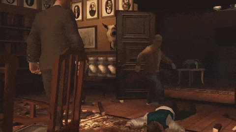 a man is laying on the floor while another man sits on the floor
