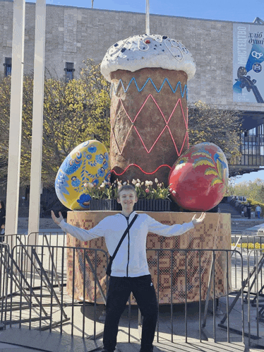 a boy stands in front of a giant easter bunny cake