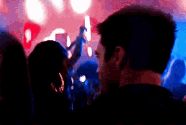 a man is standing in the middle of a crowd of people at a concert .