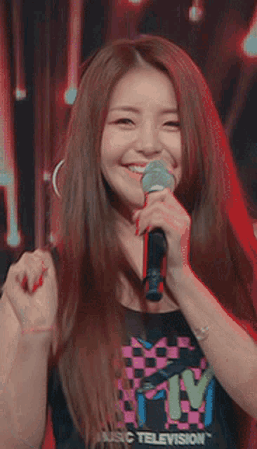 a woman is singing into a microphone while laughing