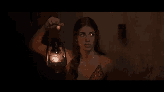 a woman in a red dress is holding a lantern in her hand