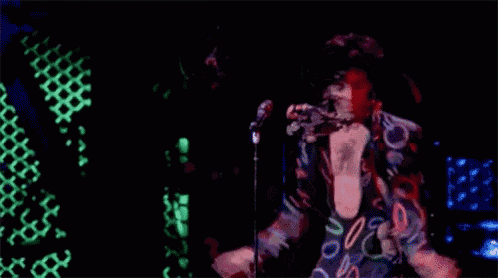 a man is singing into a microphone on a stage .