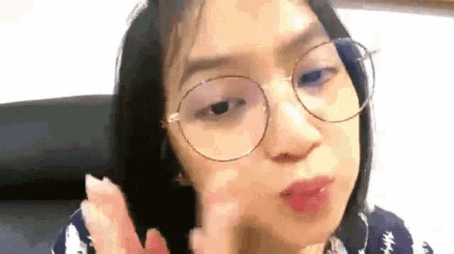 a close up of a woman wearing glasses and making a face .