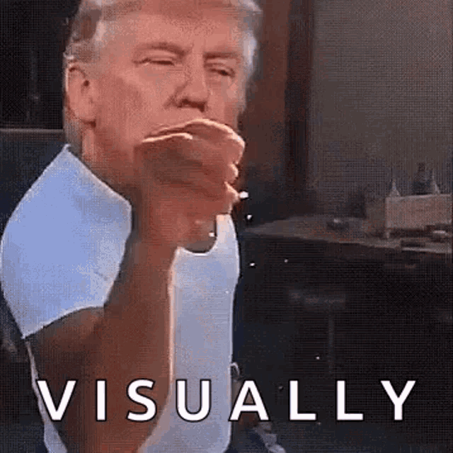a man in a white shirt is blowing a kiss while sitting in front of a table .