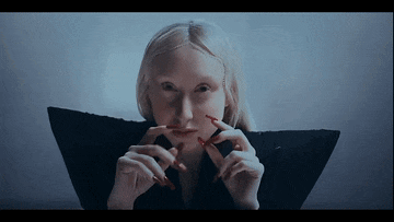 a woman with long red nails is wearing a black top
