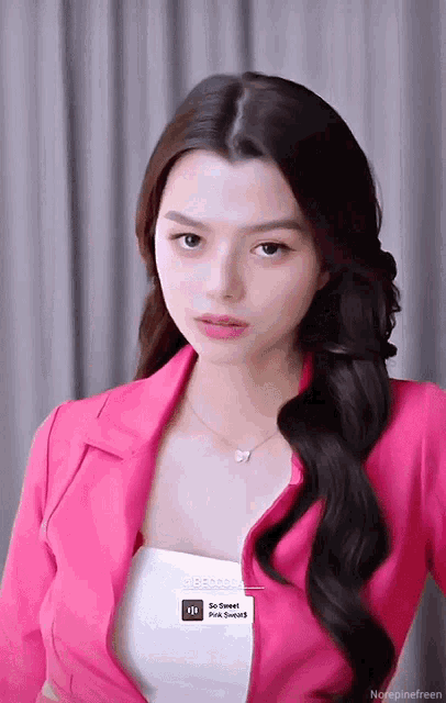 a woman is wearing a pink jacket and a white tank top with a sticker that says so sweet pink sound