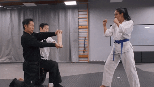 a woman in a blue belt is practicing martial arts