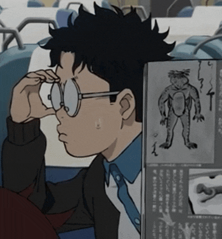 a man wearing glasses looks at a picture of a frog in a book
