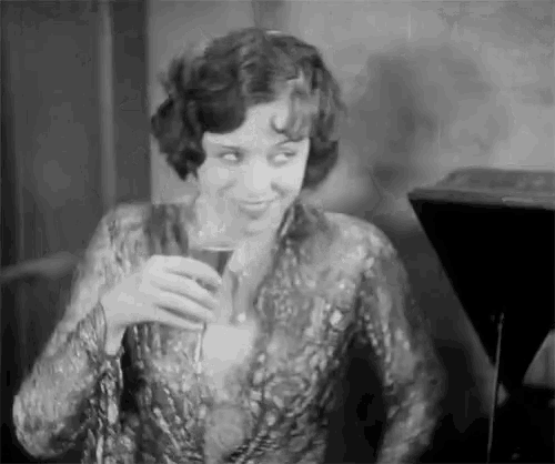 a woman is holding a glass of wine and smiling .