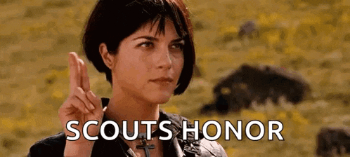 a woman is making a peace sign in a field with the words scouts honor behind her .