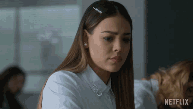 a woman in a white shirt with a netflix logo on the bottom right