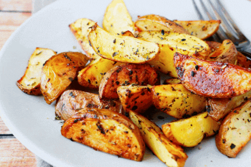 a plate of potato wedges with a fork on the side