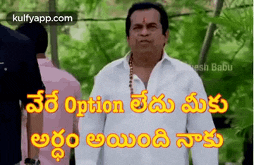 a man in a white shirt is standing in front of a group of people with a caption in telugu .