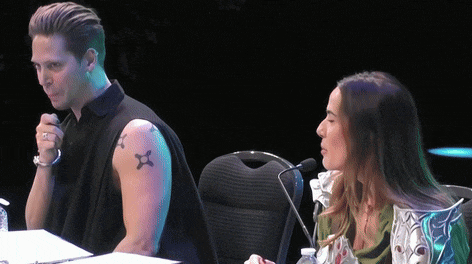 a man with a tattoo of a star on his arm sits next to a woman