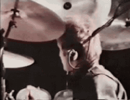a man is playing drums in front of a microphone .