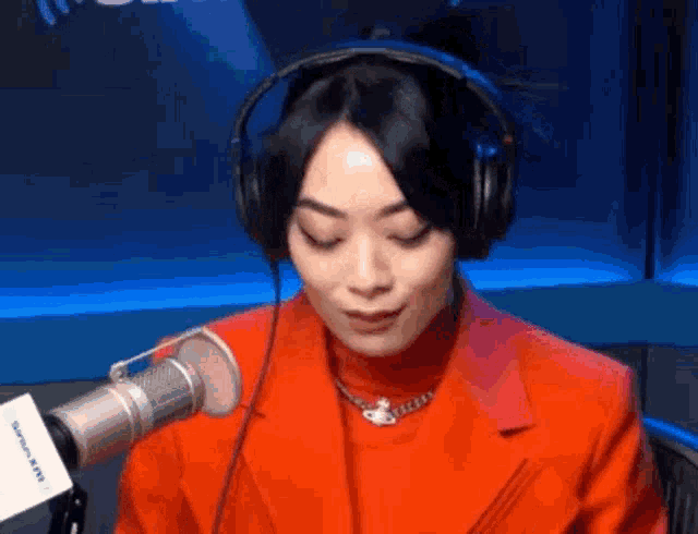 a woman wearing headphones is talking into a microphone .