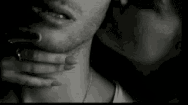 a woman is holding a man 's neck and kissing him .