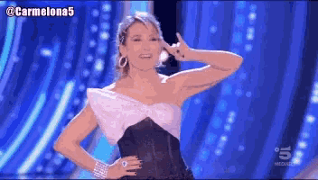 a woman in a black and white dress is dancing on a stage with the hashtag carmelona5